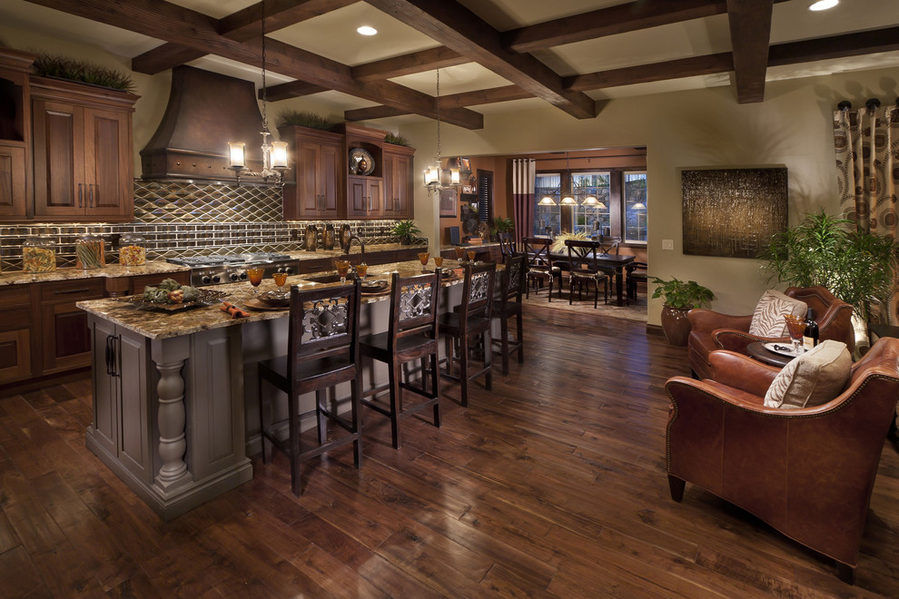 Mediterranean galley kitchen in Denver with raised-panel cabinets, dark wood cabinets and stainless steel appliances.