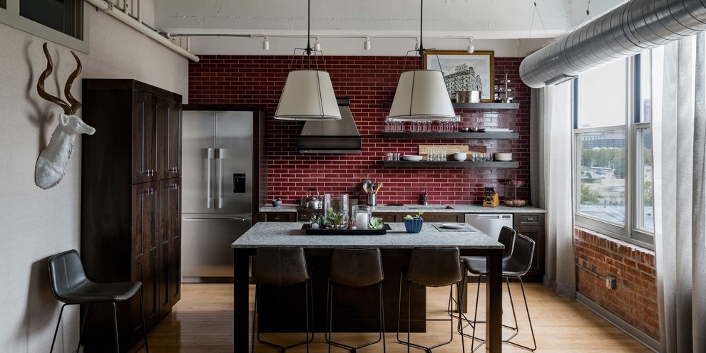 Inspiration for a mid-sized transitional galley light wood floor and yellow floor eat-in kitchen remodel with an undermount sink, shaker cabinets, dark wood cabinets, granite countertops, red backsplash, porcelain backsplash, stainless steel appliances, an island and gray countertops