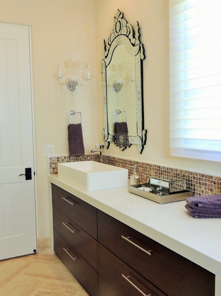 Photo of a small contemporary kids bathroom in San Diego with a vessel sink, flat-panel cabinets, dark wood cabinets, solid surface benchtops, multi-coloured tile, stone tile, beige walls and travertine floors.