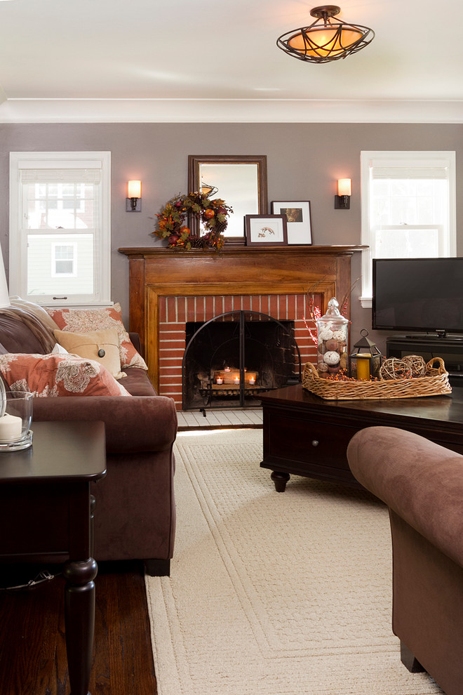 This is an example of a traditional living room in Minneapolis with grey walls, dark hardwood floors, a standard fireplace and a brick fireplace surround.