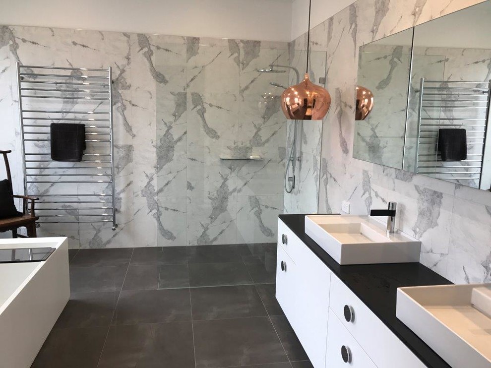 Inspiration for a contemporary bathroom in Melbourne with a freestanding tub, an open shower, white tile, porcelain tile, white walls, porcelain floors, a console sink, engineered quartz benchtops, white floor, an open shower and black benchtops.