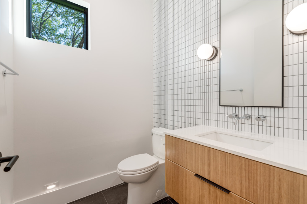 Exemple d'une salle d'eau rétro avec un placard à porte plane, des portes de placard marrons, WC séparés, un carrelage blanc, des carreaux de céramique, un mur blanc, un sol en carrelage de céramique, un lavabo encastré, un plan de toilette en quartz modifié, un sol noir, un plan de toilette blanc, des toilettes cachées, meuble simple vasque et meuble-lavabo suspendu.
