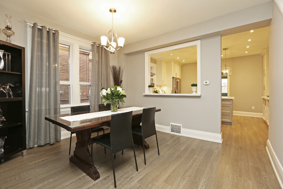 Inspiration for a mid-sized transitional separate dining room in Toronto with grey walls, light hardwood floors, no fireplace and brown floor.