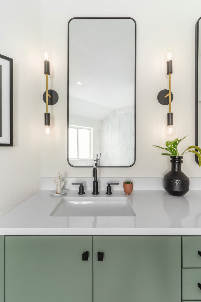 Bild på ett stort funkis vit vitt en-suite badrum, med släta luckor, gröna skåp, ett fristående badkar, vit kakel, keramikplattor, vita väggar, klinkergolv i keramik, ett nedsänkt handfat, bänkskiva i kvarts, svart golv och med dusch som är öppen