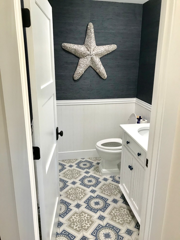 This is an example of a small beach style powder room in Miami with beaded inset cabinets, white cabinets, a two-piece toilet, multi-coloured tile, ceramic tile, grey walls, ceramic floors, an undermount sink and multi-coloured floor.