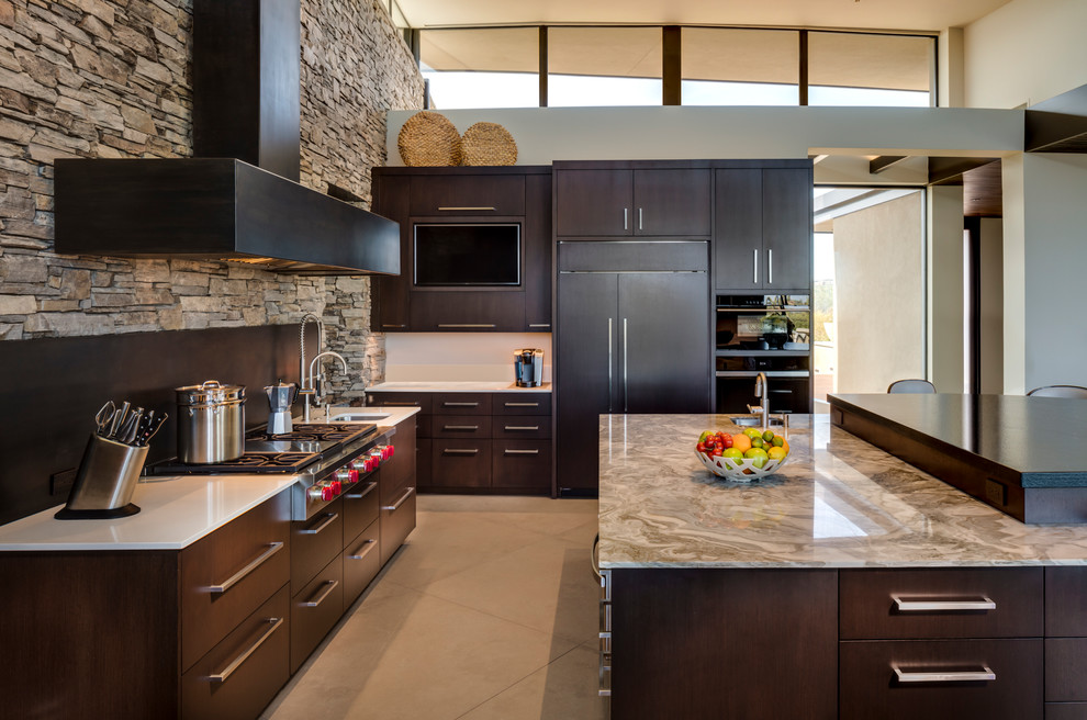 This is an example of a large contemporary u-shaped open plan kitchen in Phoenix with an undermount sink, flat-panel cabinets, dark wood cabinets, quartzite benchtops, black splashback, stainless steel appliances, porcelain floors, with island and beige floor.