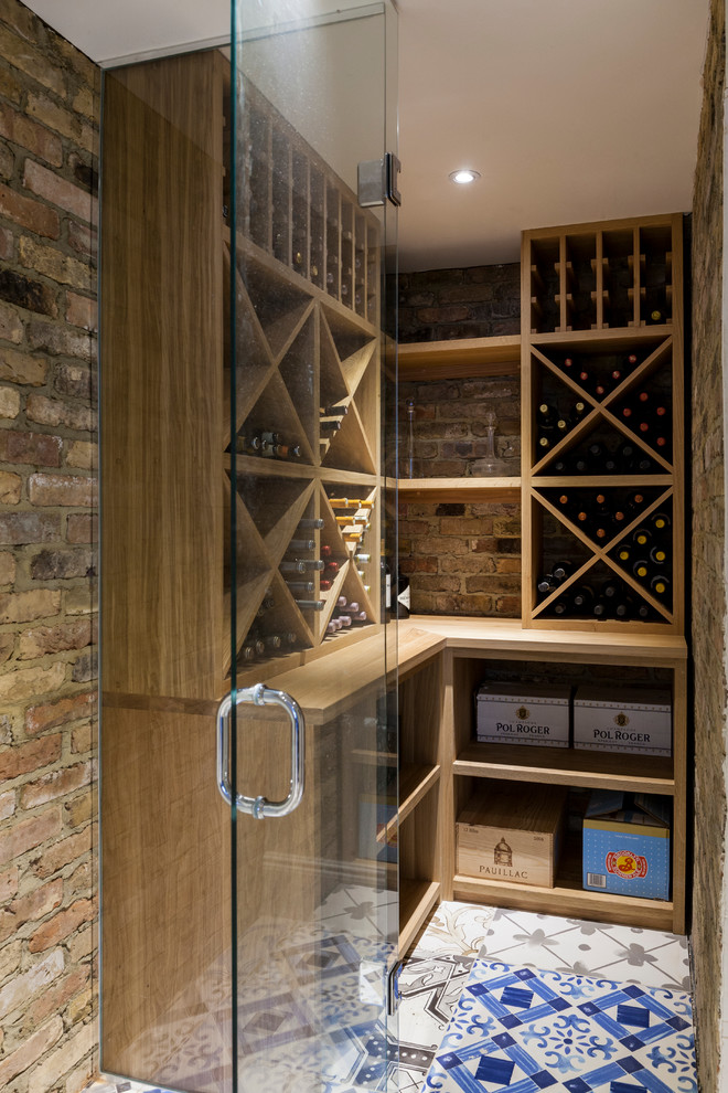 Photo of a mid-sized contemporary wine cellar in London with diamond bins and multi-coloured floor.