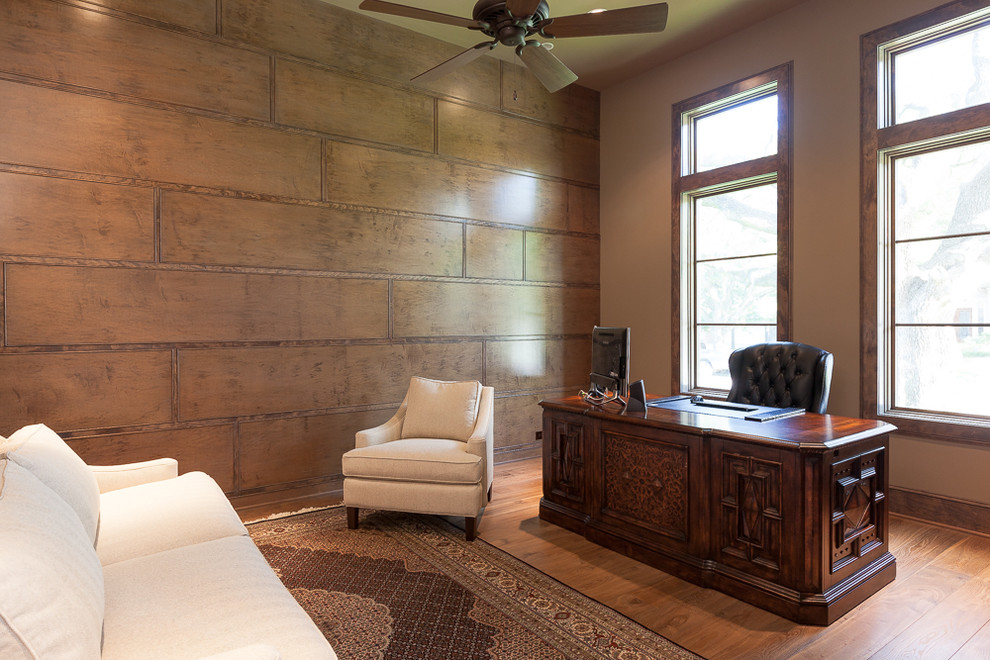 Photo of a transitional home office in Houston with brown walls, light hardwood floors and a freestanding desk.