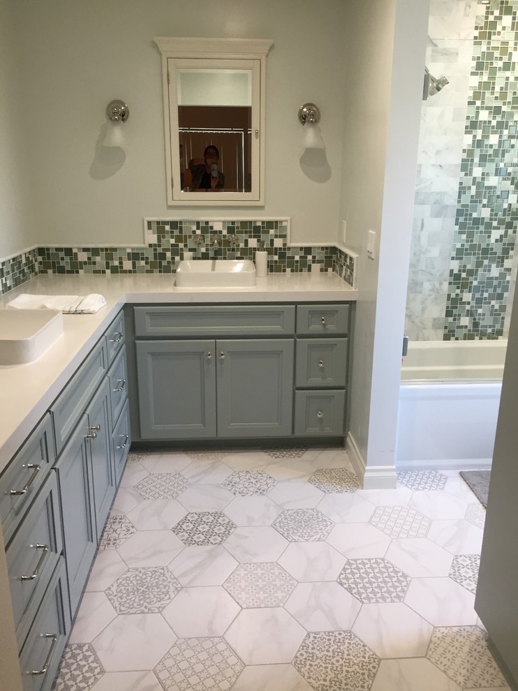 Design ideas for a mid-sized traditional master bathroom in Orange County with shaker cabinets, green cabinets, an alcove tub, a shower/bathtub combo, a one-piece toilet, gray tile, stone tile, green walls, porcelain floors, a vessel sink and engineered quartz benchtops.