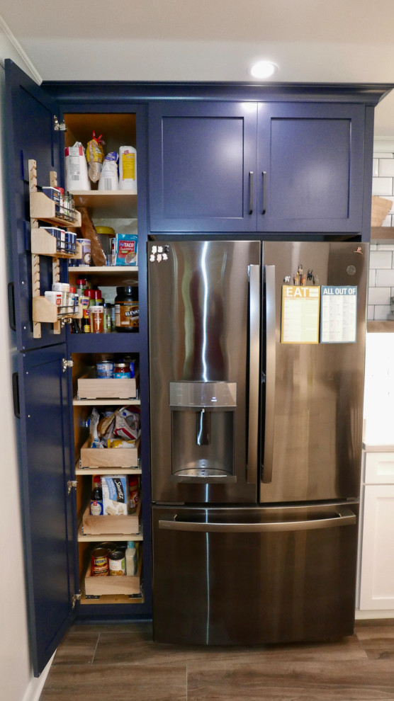Example of a mid-sized transitional galley porcelain tile and gray floor eat-in kitchen design with an undermount sink, shaker cabinets, white cabinets, quartz countertops, white backsplash, subway tile backsplash, black appliances, no island and white countertops