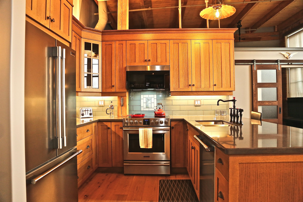 Inspiration för mellanstora amerikanska grått kök, med en undermonterad diskho, skåp i shakerstil, skåp i mellenmörkt trä, bänkskiva i kvarts, rostfria vitvaror, mellanmörkt trägolv, en halv köksö och brunt golv