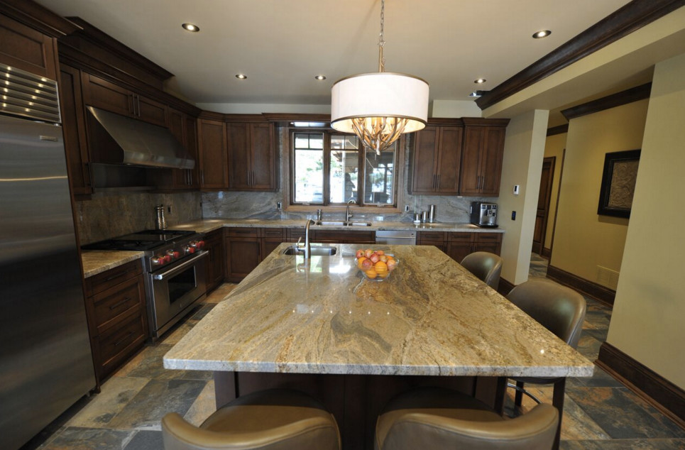 Example of a large mountain style galley dark wood floor open concept kitchen design in Boston with an undermount sink, shaker cabinets, white cabinets, granite countertops, stainless steel appliances and an island