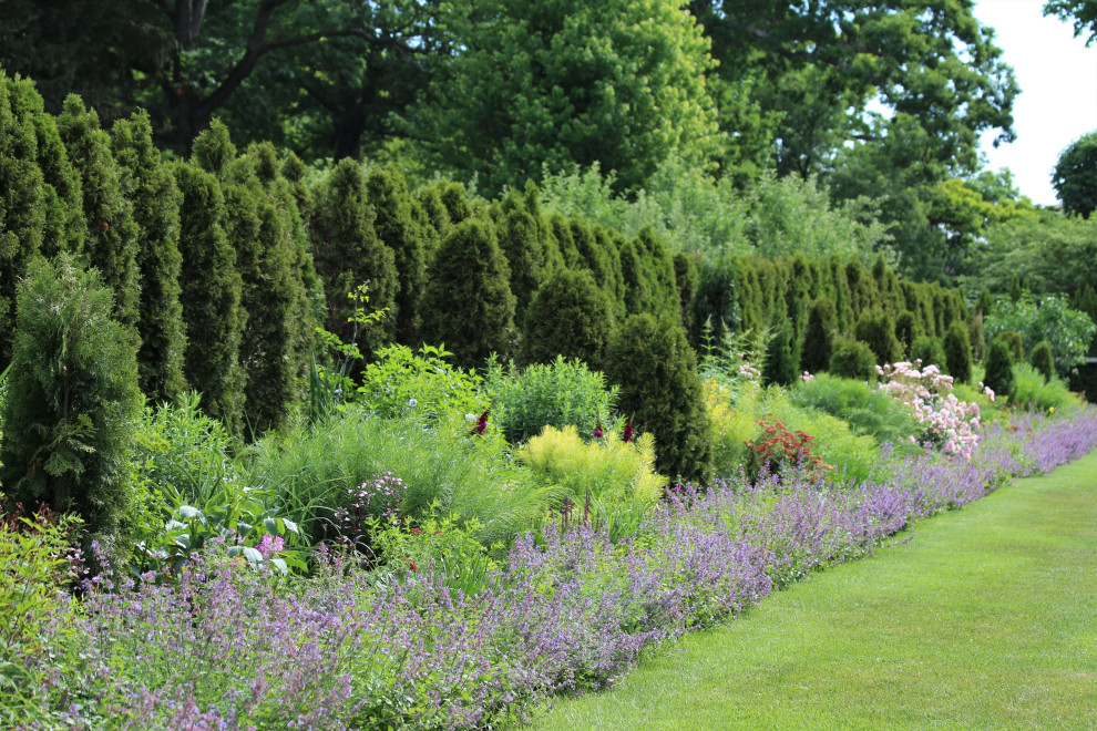 Idées déco pour un grand jardin à la française arrière victorien l'été avec un massif de fleurs et une exposition ensoleillée.