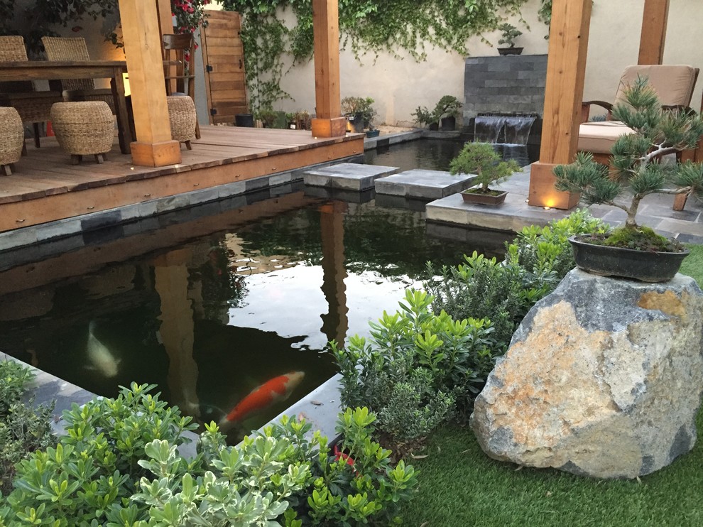 Inspiration for a mid-sized modern backyard shaded formal garden in Los Angeles with decking.