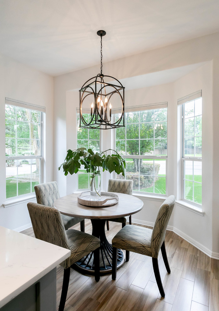 Eat-in kitchen - transitional u-shaped porcelain tile and brown floor eat-in kitchen idea in Austin with a double-bowl sink, gray cabinets, quartz countertops, white backsplash, ceramic backsplash, black appliances and an island