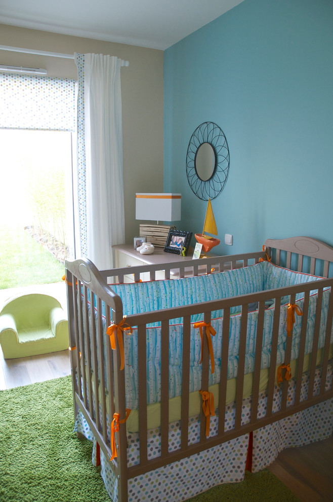 This is an example of a small contemporary gender-neutral nursery in Nantes with medium hardwood floors.