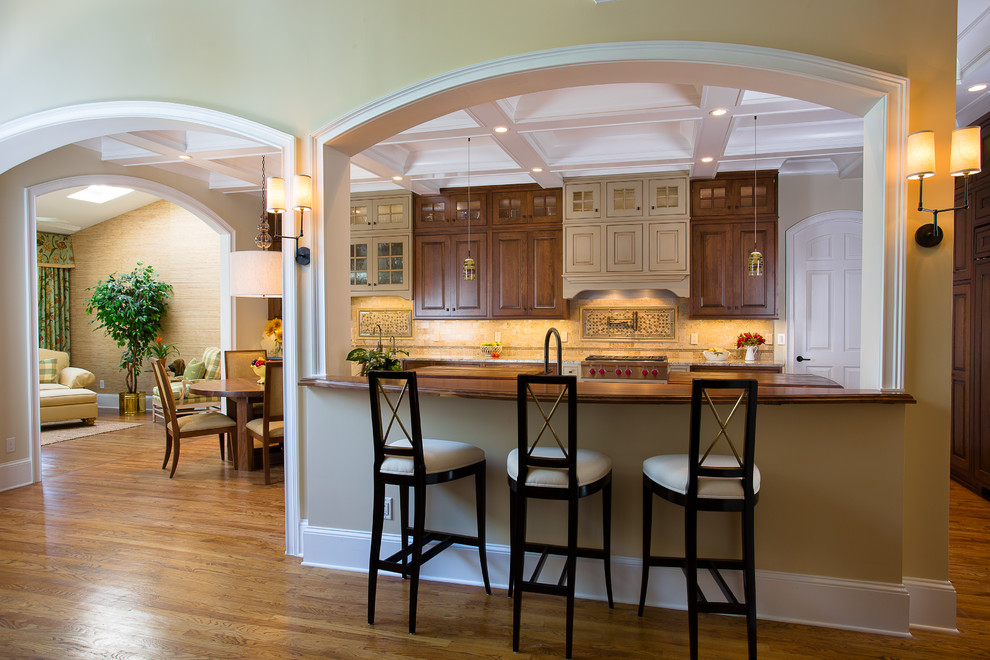 Design ideas for a large traditional u-shaped eat-in kitchen in Atlanta with a double-bowl sink, raised-panel cabinets, brown cabinets, marble benchtops, beige splashback, marble splashback, panelled appliances, medium hardwood floors, multiple islands and brown floor.