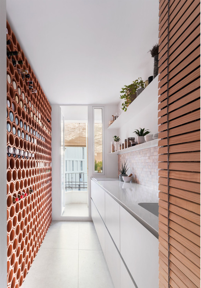 Inspiration for a mid-sized scandinavian single-wall open plan kitchen in Valencia with a single-bowl sink, louvered cabinets, beige cabinets, stainless steel benchtops, multi-coloured splashback, cement tile splashback, panelled appliances, ceramic floors, no island, grey floor and white benchtop.