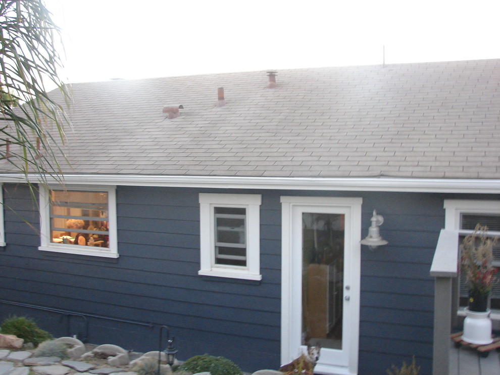 Photo of a mid-sized beach style one-storey blue house exterior in Los Angeles with wood siding, a clipped gable roof and a shingle roof.