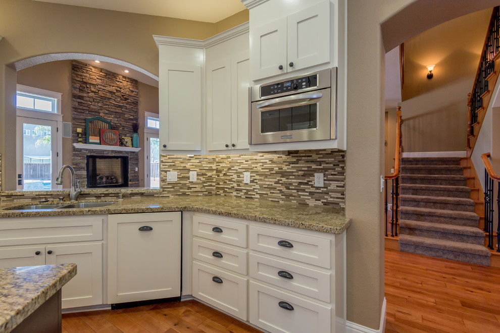 Inspiration for a large traditional l-shaped eat-in kitchen in Sacramento with an undermount sink, shaker cabinets, white cabinets, terrazzo benchtops, brown splashback, matchstick tile splashback, stainless steel appliances, medium hardwood floors, with island and brown floor.