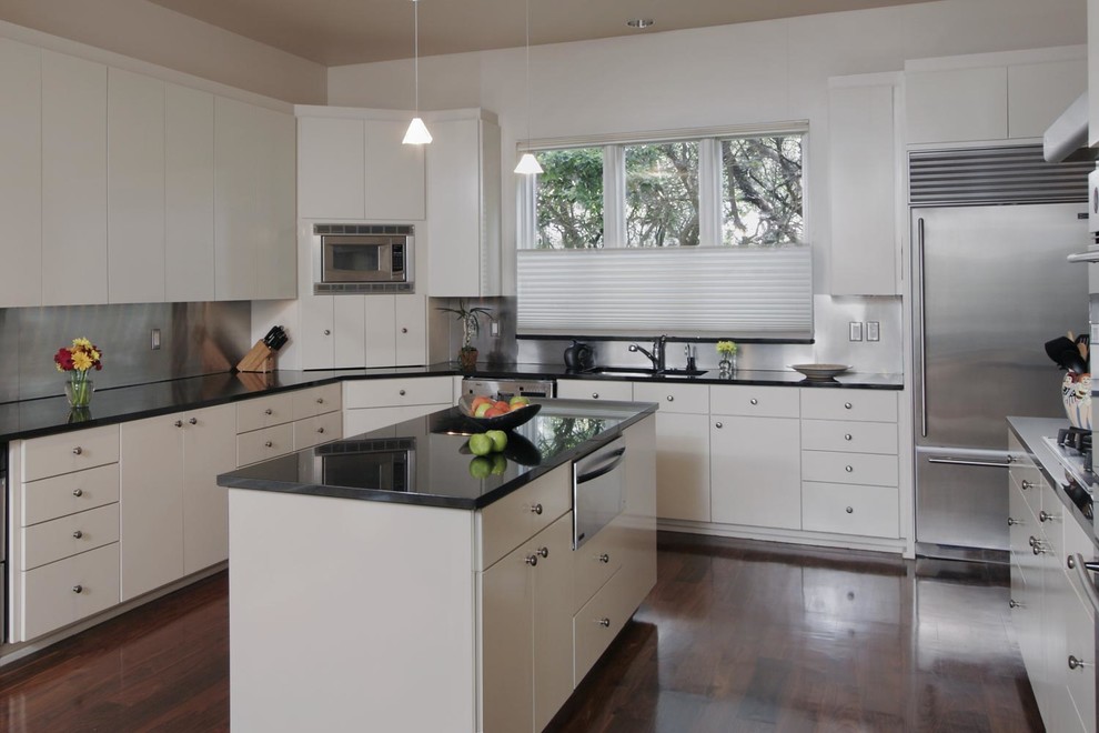 Photo of a large contemporary u-shaped eat-in kitchen in Austin with a double-bowl sink, flat-panel cabinets, white cabinets, granite benchtops, metallic splashback, metal splashback, stainless steel appliances, dark hardwood floors and with island.
