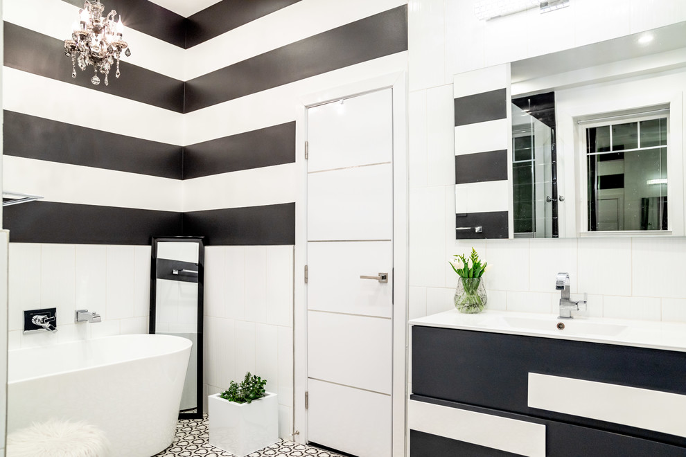 Mid-sized contemporary master bathroom in DC Metro with flat-panel cabinets, black cabinets, a freestanding tub, an integrated sink, black floor and white benchtops.