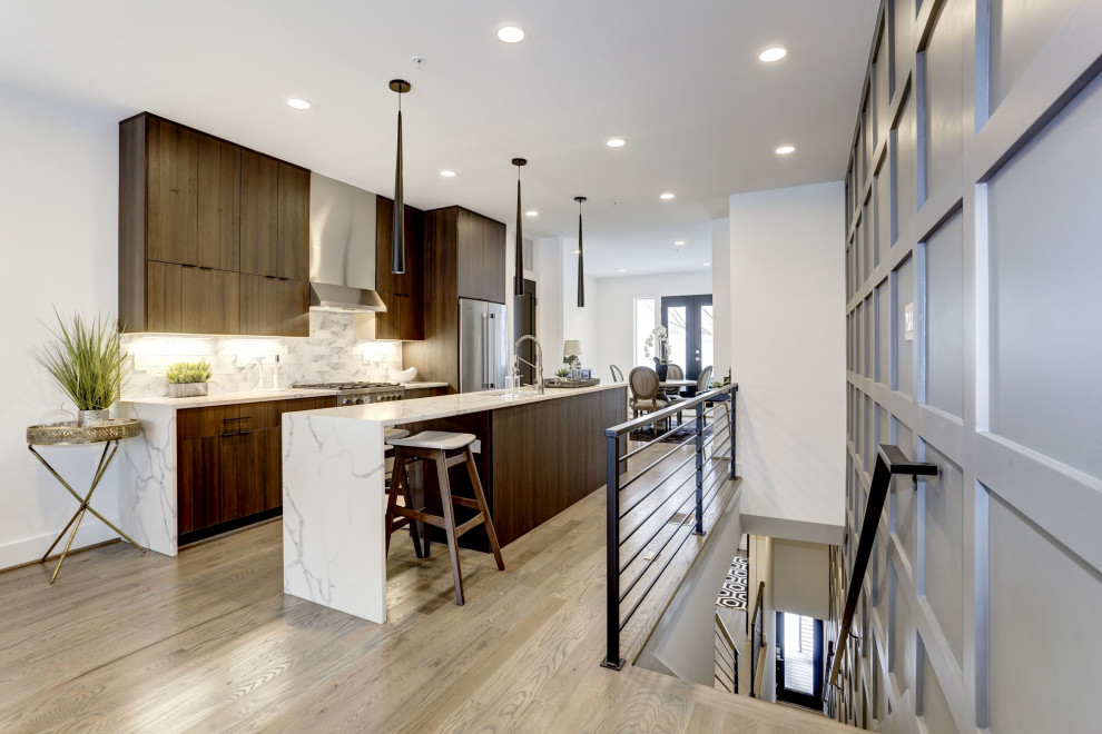 Inspiration for a transitional galley medium tone wood floor and brown floor eat-in kitchen remodel in DC Metro with an undermount sink, flat-panel cabinets, medium tone wood cabinets, multicolored backsplash, stainless steel appliances, an island and multicolored countertops