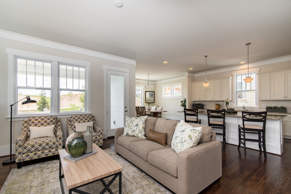 Traditional open concept living room in Charlotte with beige walls, medium hardwood floors and brown floor.