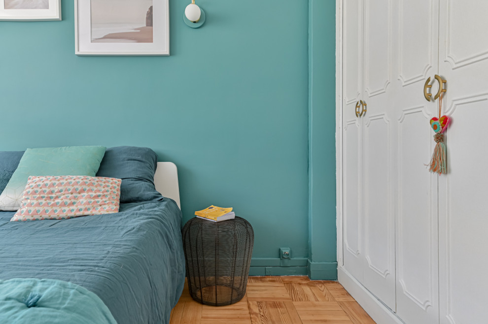 Réalisation d'une chambre parentale design de taille moyenne avec un mur bleu, un sol beige et dressing.
