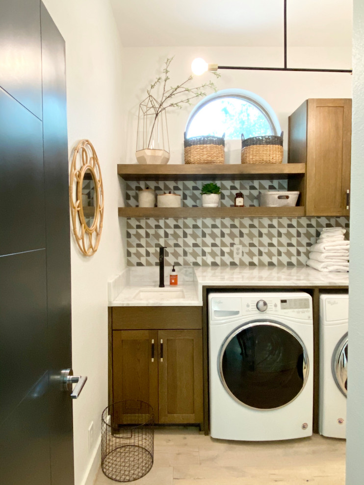 Minimalist single-wall light wood floor and beige floor dedicated laundry room photo in Austin with an undermount sink, shaker cabinets, medium tone wood cabinets, quartzite countertops, multicolored backsplash, marble backsplash, a side-by-side washer/dryer and white countertops