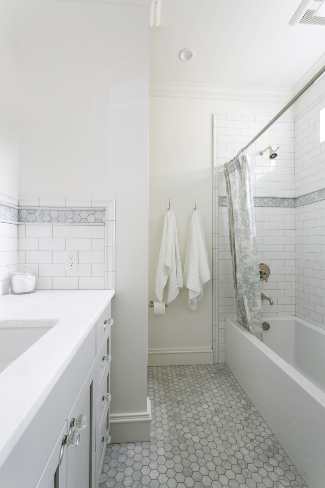 Design ideas for a small transitional bathroom in Charleston with recessed-panel cabinets, grey cabinets, an alcove tub, an alcove shower, a one-piece toilet, white tile, ceramic tile, white walls, marble floors, an undermount sink, marble benchtops, white floor, a shower curtain and white benchtops.