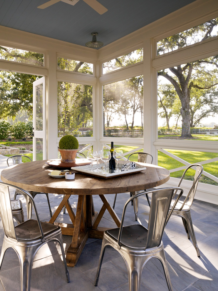 Design ideas for a country screened-in verandah in San Francisco with a roof extension and natural stone pavers.