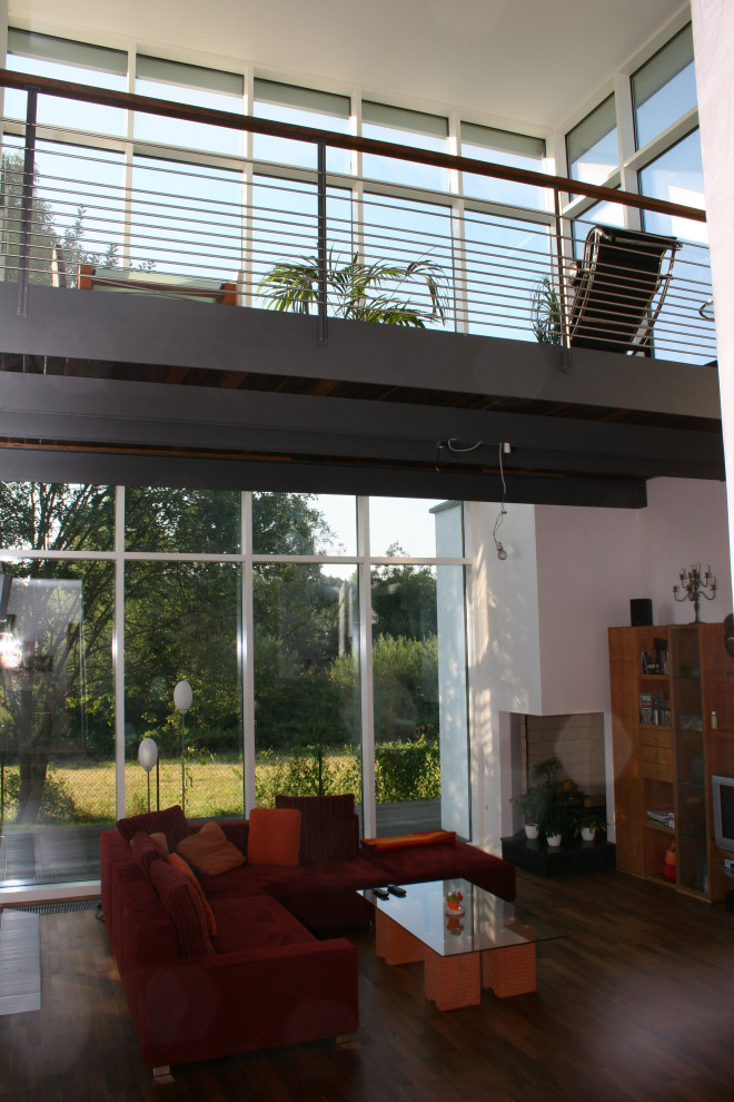 Geräumiger Moderner Wintergarten mit dunklem Holzboden, normaler Decke und braunem Boden in Sonstige