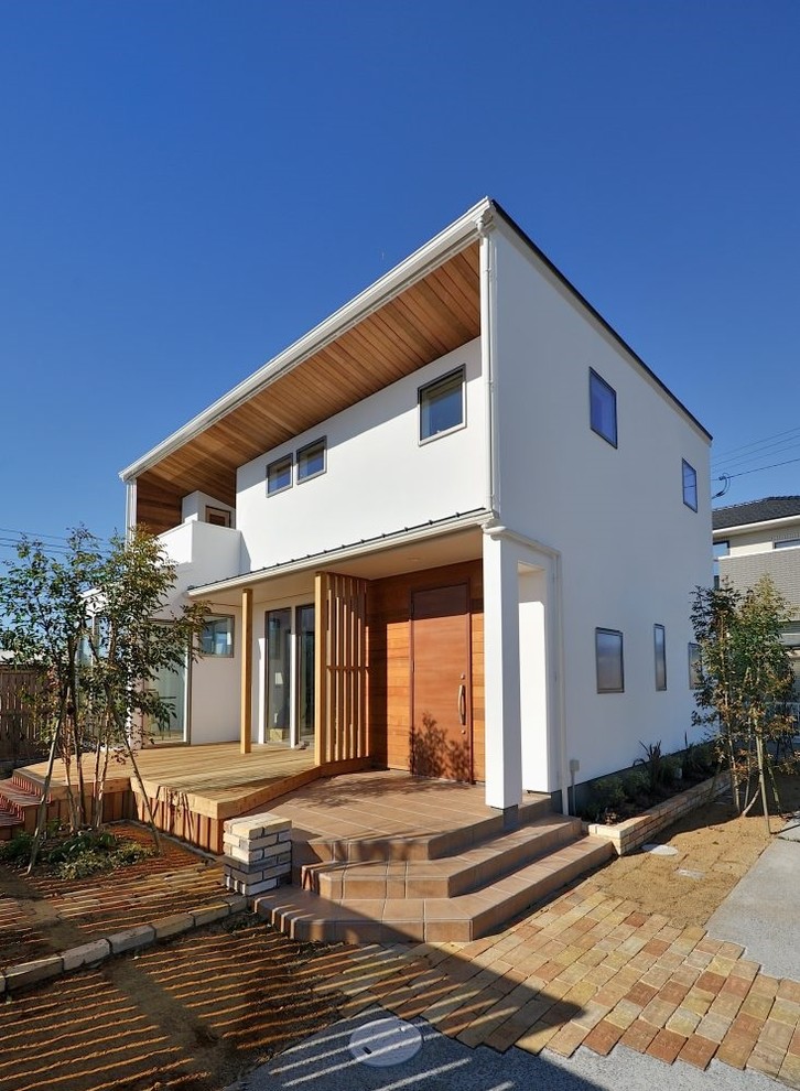 This is an example of an asian white exterior in Other with a flat roof.