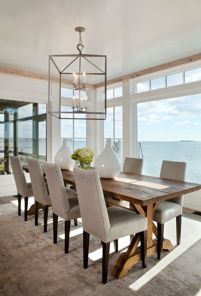 This is an example of a beach style dining room in New York with beige floor.