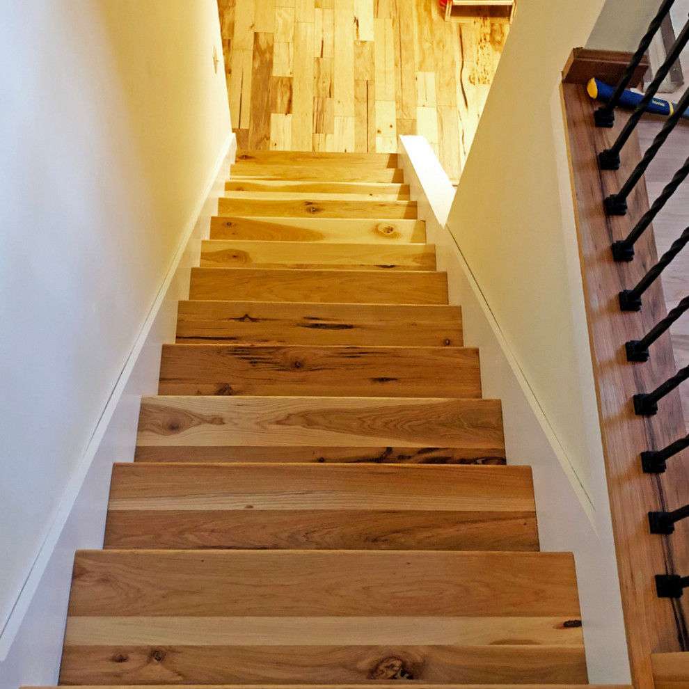 This is an example of a mid-sized country wood straight staircase in Other with wood risers and planked wall panelling.
