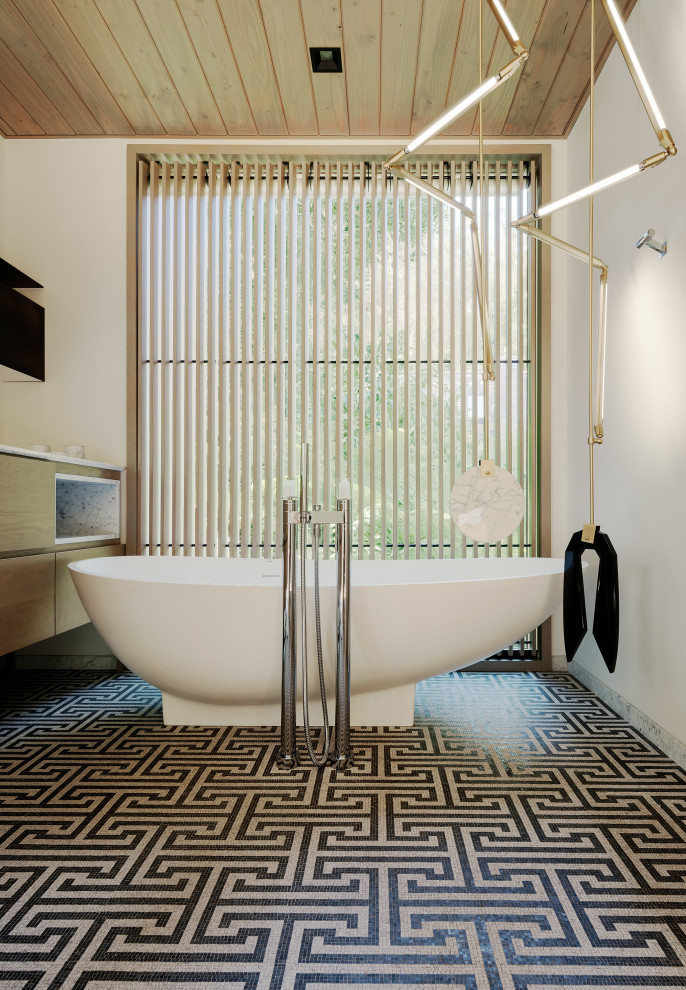 This is an example of a modern bathroom in San Francisco with flat-panel cabinets, medium wood cabinets, a freestanding tub, white walls, mosaic tile floors and multi-coloured floor.
