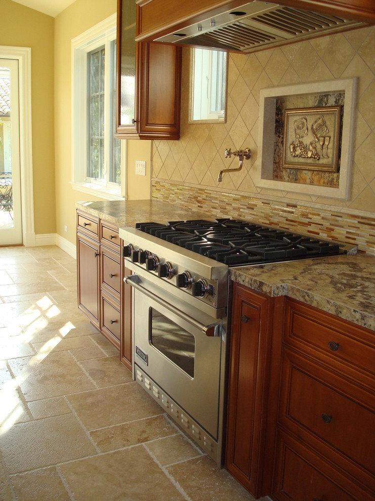 Large mountain style galley limestone floor and beige floor open concept kitchen photo with a farmhouse sink, beaded inset cabinets, medium tone wood cabinets, granite countertops, beige backsplash, mosaic tile backsplash, stainless steel appliances, an island and brown countertops
