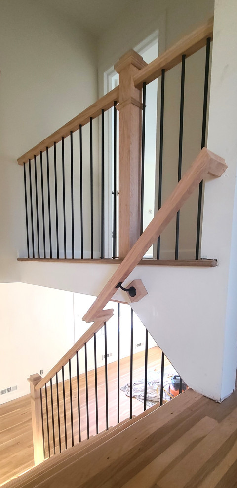 Modelo de escalera en L actual de tamaño medio con escalones de madera, contrahuellas de madera y barandilla de varios materiales