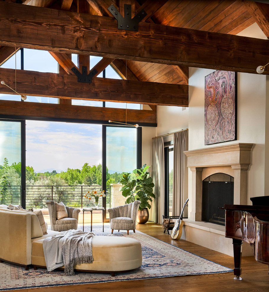 Exemple d'un grand salon nature ouvert avec une salle de réception, un sol en bois brun, une cheminée standard, un manteau de cheminée en plâtre et aucun téléviseur.