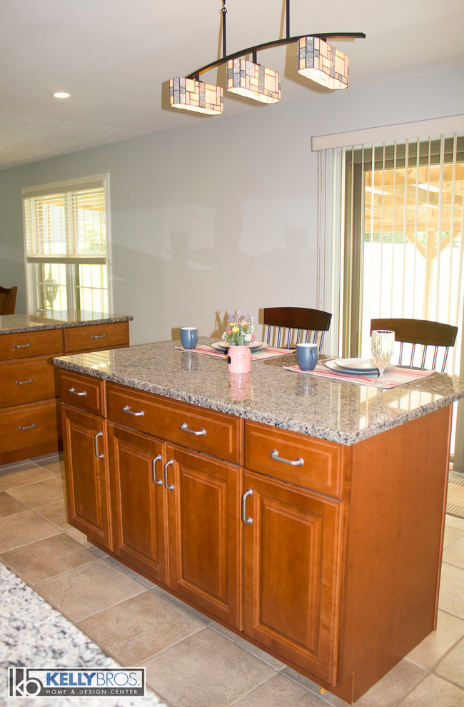 Home design - large transitional u-shaped ceramic tile home design idea in Cincinnati with a double-bowl sink, raised-panel cabinets, medium tone wood cabinets, granite countertops, stainless steel appliances and an island