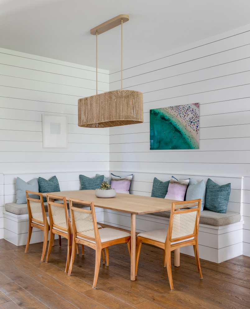Idée de décoration pour une salle à manger design de taille moyenne avec une banquette d'angle, un mur blanc, un sol en bois brun et aucune cheminée.