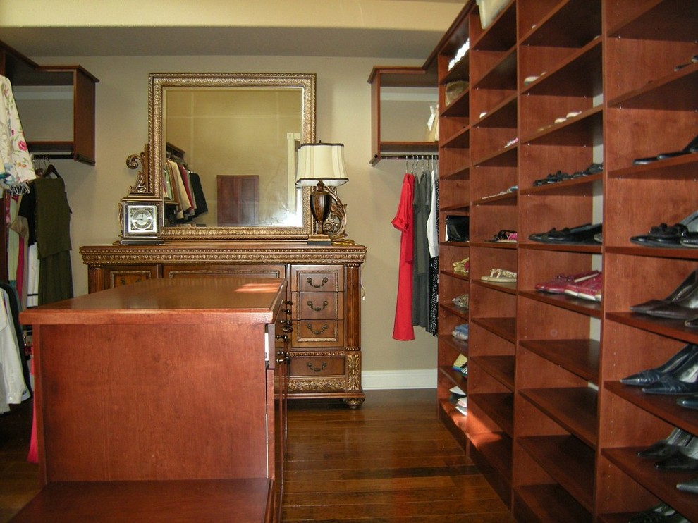 Large traditional women's dressing room in Miami with open cabinets, dark wood cabinets, dark hardwood floors and brown floor.
