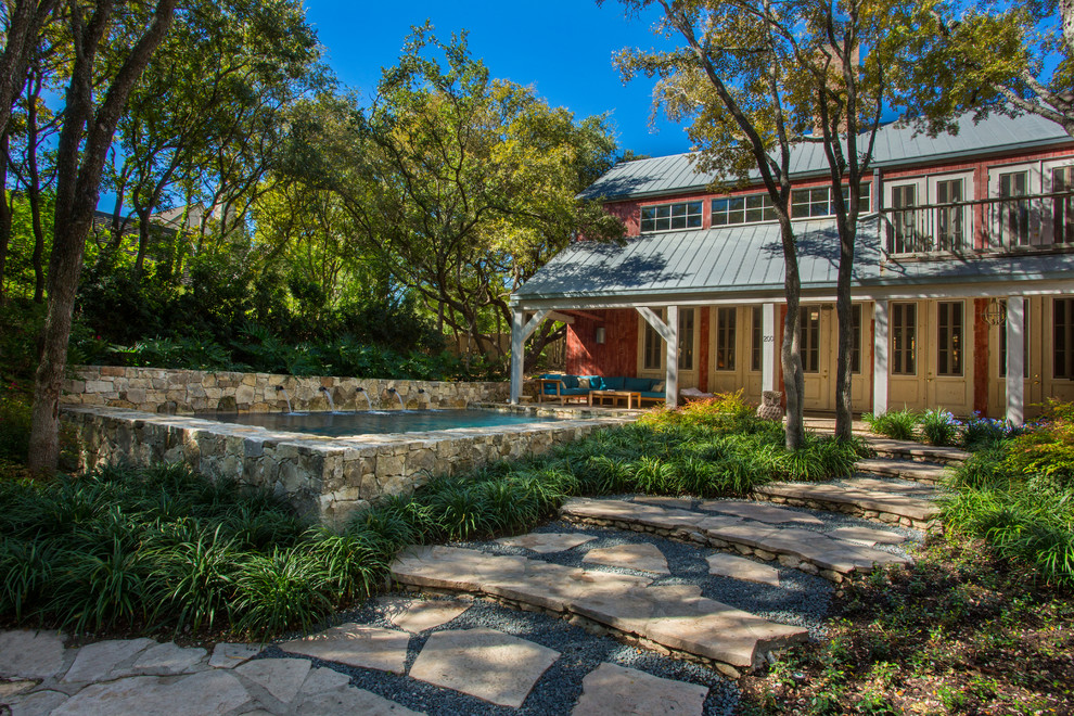 This is an example of a country rectangular aboveground pool in Austin with a water feature.