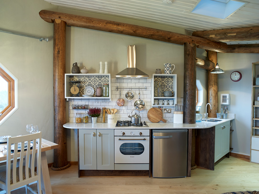 Photo of a small rustic single-wall kitchen in Other with a submerged sink, shaker cabinets, grey cabinets, white splashback, metro tiled splashback, white appliances, medium hardwood flooring and no island.