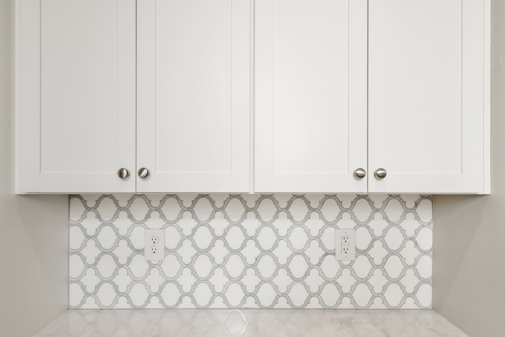 Kitchen pantry - mid-sized transitional u-shaped vinyl floor and brown floor kitchen pantry idea with a farmhouse sink, shaker cabinets, white cabinets, quartz countertops, white backsplash, marble backsplash, black appliances, two islands and white countertops