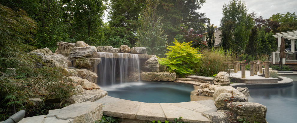 Design ideas for a mid-sized country backyard custom-shaped natural pool in Toronto with a hot tub and brick pavers.