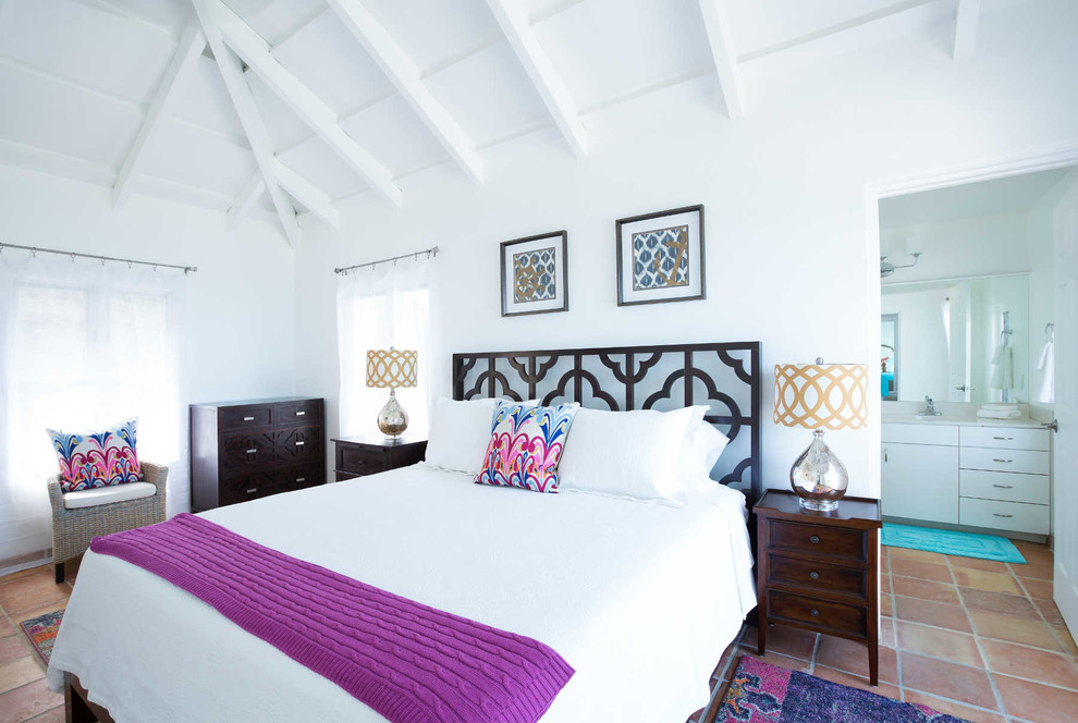 Photo of a large tropical bedroom in Other with white walls and terra-cotta floors.