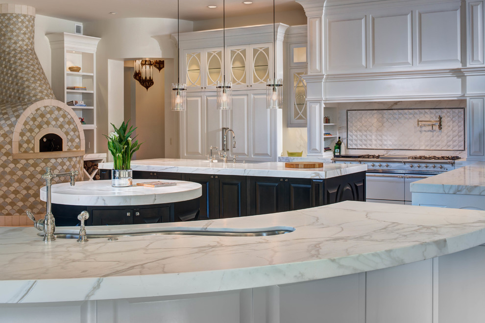 Inspiration for a large transitional l-shaped eat-in kitchen in Salt Lake City with white cabinets, marble benchtops, white splashback, stainless steel appliances and multiple islands.