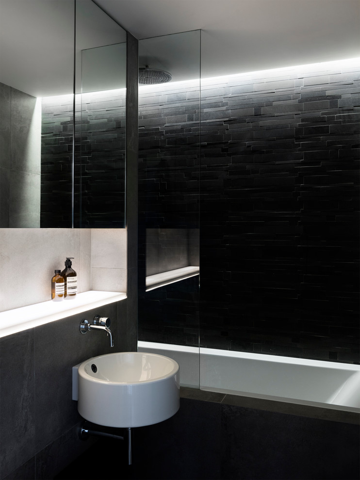 Inspiration for a small contemporary bathroom in London with a drop-in tub, a shower/bathtub combo, a wall-mount toilet, porcelain tile, porcelain floors and a wall-mount sink.